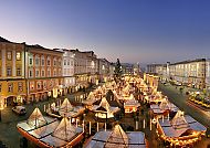 Linz, Weihnachtsmarkt in Linz bei Abenddämmerung, festliche Lichter.