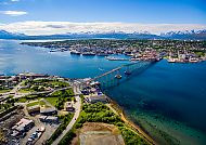 Tromso (Roue 2), Tromsø mit Brücke und Fjordlandschaft unter blauem Himmel.