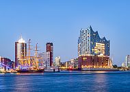 Hamburg, Hamburgs Elbphilharmonie und Hafen im Abendlicht.