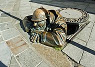Bratislava, Gullymann, Bratislava: Gullymann-Statue ragt aus einem Kanaldeckel hervor., Bratislava: Gullymann-Statue ragt aus dem Gehweg heraus.