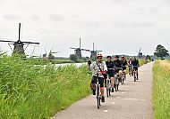 Kinderdijk, Radfahrer vor den Windmühlen von Kinderdijk in Südholland.