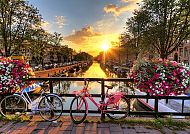 Amsterdam, Sonnenuntergang über Amsterdams Kanälen mit Fahrrädern und Blumen., Sonnenuntergang über Amsterdamer Kanal mit Fahrrädern und Blumen.