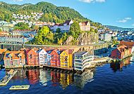 Bergen, Bunte Häuser am Wasser in Bergen, umgeben von herbstlichen Wäldern.