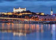 Bratislava, Bratislava bei Nacht, beleuchtete Burg und Donau im Vordergrund.