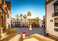 La Palma, Kanaren, Malerischer Platz auf La Palma mit Palmen und historischer Architektur., Historischer Platz mit Palmen auf La Palma bei Sonnenuntergang.