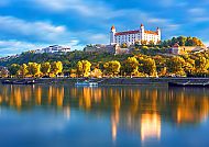 Bratislava, Bratislava: Majestätische Burg über der glitzernden Donau., Bratislava mit der Burg und der Donau bei Sonnenuntergang.