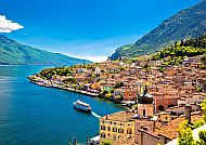 Blick auf Limone am Gardasee, umgeben von Bergen und blauem Wasser., Limone am Gardasee mit malerischem Blick auf Berge und Wasser.