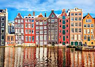 Ausflugstipp: Amsterdam, Bunte Grachtenhäuser in Amsterdam spiegeln sich im Wasser