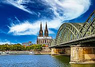 Köln, Kölner Dom und Hohenzollernbrücke am Rhein unter blauem Himmel., Kölner Dom und Hohenzollernbrücke am Rhein bei strahlendem Himmel.