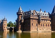 Utrecht, Schloss de Haar in Utrecht, umgeben von Wasser und blauem Himmel.