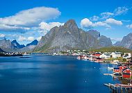 Malerisches Dorf Reine vor majestätischen Bergen und blauem Meer.