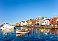 Stavanger (nur Route 1), Bunte Hafenansicht in Stavanger bei klarem Himmel., Bunte Häuser und Boote im Hafen von Stavanger bei klarem Himmel.