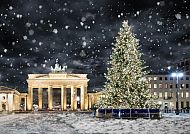 Berlin, Brandenburger Tor im Schnee mit festlichem Weihnachtsbaum.