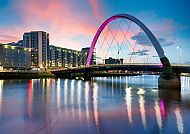 Glasgow (Route 2), Glasgow bei Sonnenuntergang mit beleuchteter Brücke und Fluss., Glasgow bei Sonnenuntergang mit beleuchteter Clyde Arc Brücke.