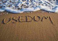 Usedom-Schriftzug am Strand, Usedom-Schriftzug im Sand am Strand mit sanften Wellen., Usedom-Schriftzug im Sand am Strand mit sanften Wellen.