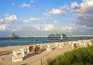Heringsdorf, Strandkörbe und Seebrücke in Heringsdorf bei Sonnenschein., Strandkörbe am Heringsdorfer Strand mit Seebrücke im Hintergrund.