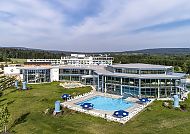 SiebenQuell, Siebenquell® GesundZeitResort mit Pool und grüner Umgebung.