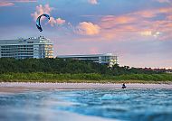 Hotelansicht, Radisson Blu Resort Swinemünde mit Kitesurfer bei Sonnenuntergang.