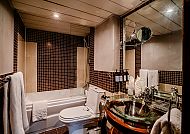 Modernes Badezimmer mit Glaswaschbecken und Mosaikfliesen.