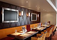 Elegantes Restaurant mit gedeckten Tischen und warmer Beleuchtung.