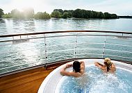 Whirlpool auf Deck mit Blick auf ruhigen See bei Sonnenuntergang.