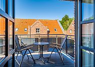 , Gemütlicher Balkon mit Blick auf Ziegeldächer in Greetsiel.