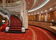 Elegante Lobby der QUEEN MARY 2 mit rotem Teppich und Treppe.